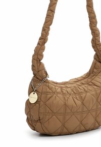 Brūna dūraiņu stila rokassoma ar mīkstu, pūkainu faktūru, pīnētu plecu siksnu un dekoratīvu zelta ķēdes un uzlīmes detaļu. Augšējā daļa aizdarāma ar rāvējslēdzēju.