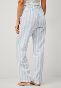 Blauwe en witte gestreepte losse broek met een elastische tailleband en zijzakken, gemaakt van lichtgewicht, ademend materiaal.