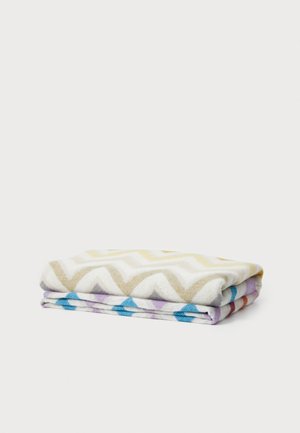 Multifarget håndklær med et chevron-mønster i beige, hvitt og blått, pent brettet med en myk tekstur.