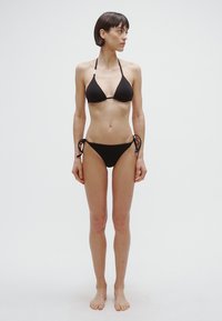 Črni bikini komplet z vrhnjim delom v obliki trikotnika z nastavljivimi trakovi in spodnjim delom z vezalko na strani. Material je gladek z minimalnim dizajnom.