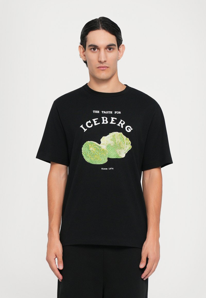 Black cotton t-shirt with short sleeves featuring a graphic of two iceberg lettuce heads and text reading "THE TASTE FOR ICEBERG Since 1974."
