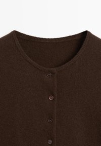 Brauner Strickcardigan mit rundem Ausschnitt, der vorne vier dunkle Knöpfe hat und eine weiche Textur aufweist. Ohne Muster oder Details.