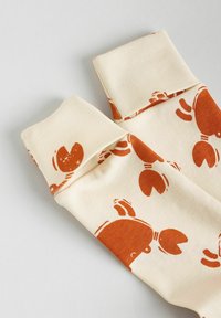 Cream socks with a repeating orange lobster pattern, featuring a folded cuff and a smooth, soft texture.