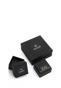 Tre sorte Kuzzoí mærkede smykkebokse, en åben, på en hvid baggrund, der viser et økologisk venligt FSC-certificeret mærke.