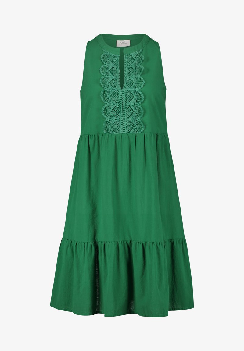 Vihreä puuvillamekko, jossa on pyöreä pääntie, pitsiyksityiskohtia keskellä ja röyhelöhelma. Hihaton malli ja polven pituinen istuvuus.