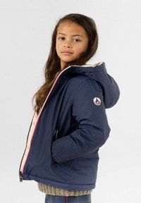Giubbotto puffa navy con cappuccio, zip frontale e fodera rosa. Presenta tasche laterali e una patch con logo sulla manica sinistra.