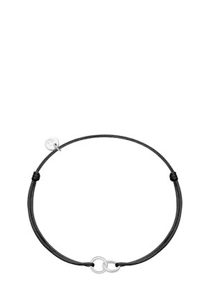Pulsera de cordón negro ajustable con dos anillos plateados entrelazados y un pequeño charm redondo de plata grabado con un trébol.