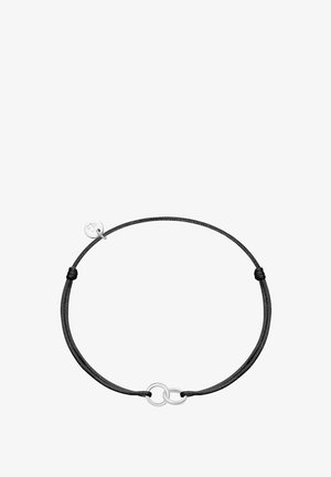 Pulsera de cordón negro ajustable con dos anillos plateados entrelazados y un pequeño charm redondo de plata grabado con un trébol.