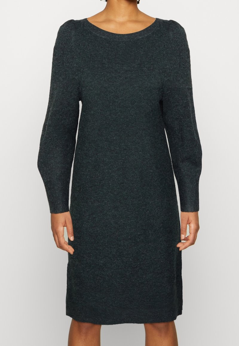 Stickad klänning i mörkgrön, med rund halsringning, långa ärmar och rak silhuett. Mjuk textur, minimala sömmar och avslappnad design.