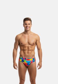 Colorful swim briefs featuring a patchwork design in bright tones of red, blue, yellow, and green, made from smooth fabric with an elastic waistband.