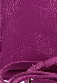 Roze leren handtas met een gestructureerd oppervlak, voorzien van een dunne schouderband en een gladde sluiting. Het materiaal vertoont een licht gekreukt uiterlijk.