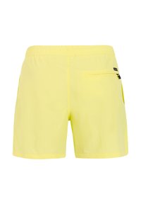 Shorts gialli con vita elasticizzata, tasca posteriore con zip sul lato destro e una piccola etichetta nera del marchio.