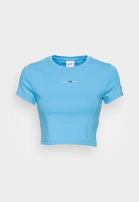 Vaaleansininen lyhythihainen cropped t-paita, joka on valmistettu pehmeästä puuvillasta. Siinä on lyhyet hihat ja pyöreä kaula-aukko, johon on brodeerattu "TOMMY JEANS" -logo keskelle.