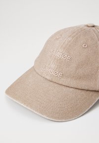 Baseball cap in light beige fabric with subtle texture, featuring the brand name "SAMØSØE" embroidered in a matching color. Curved brim design.