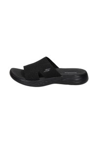 Zwarte slide sandaal met mesh bovenkant en een open ontwerp. Gecontourde voetbed en geprofileerde zool voor grip. Beschikt over een subtiele merklogo op de band.