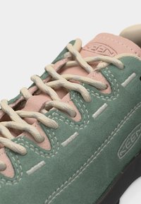 Baskets en daim vert et rose avec des lacets beige, des coutures blanches détaillées et le logo KEEN sur le côté et la languette.