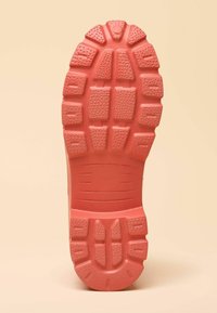 Suola di scarpa in gomma di colore corallo, con un motivo strutturato, tasselli di trazione squadrati e un'area liscia con l'indicazione della taglia.