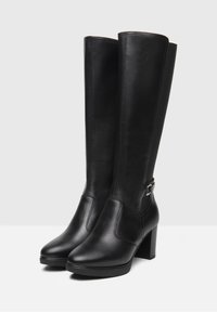 Black leather knee-high boots with a block heel, smooth texture, pointed toe, and side buckle accent. Stitched detailing along the seams.