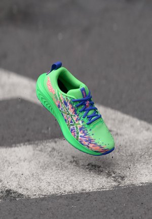 Klart grön sportskor med en texturerad mesh-övredel och livfulla, flerfärgade mönster, blå snören och en vadderad sula.