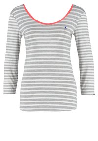 Top rayé à manches longues en gris et blanc avec un col rond. Présente une bordure corail et un petit logo bleu en accent sur la poitrine.