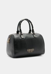 Schwarze Lederhandtasche mit strukturiertem Shape, goldfarbener Hardware und Logo. Verfügt über doppelte, gerollte Griffe und einen Reißverschluss. Texturierte Oberfläche.