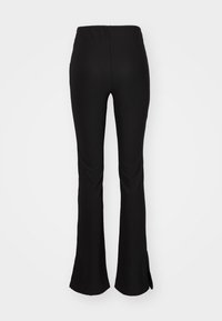 Μαύρο φαρδύ παντελόνι με ριγωτή υφή, διαθέτει ελαστική μέση και πλαϊνές σχισμές στο στρίφωμα, σχεδιασμένο για εφαρμοστή εμφάνιση.