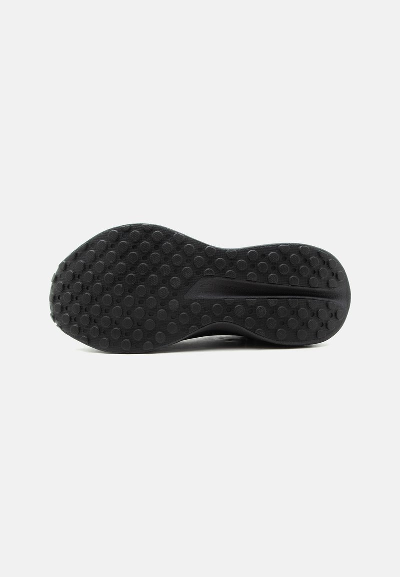 Suola di scarpa in gomma nera con motivo di battistrada circolare e una scanalatura centrale, mostrata in orizzontale su sfondo bianco.