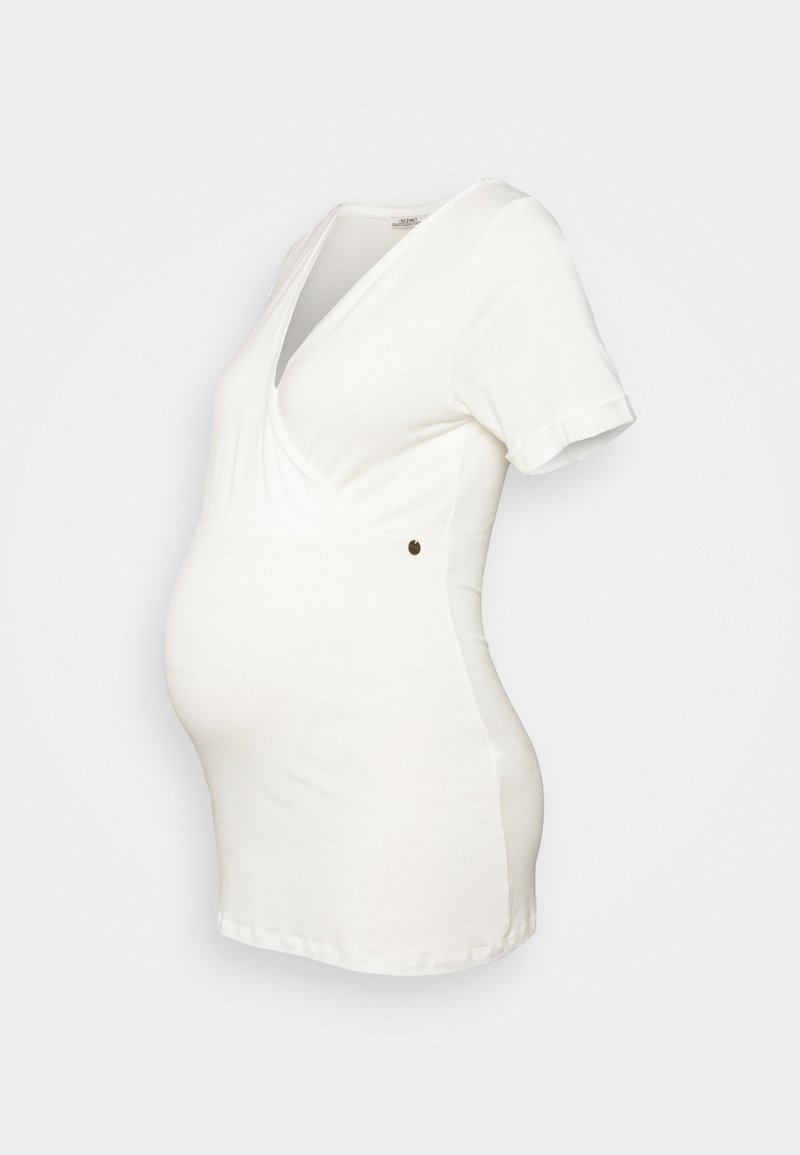 Top de maternidade branco de manga curta com um decote em V profundo e um design cruzado, featuring um detalhe de botão decorativo de lado. Textura de tecido suave.