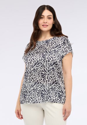 Top de manga corta en una tela ligera con un patrón de hojas en azul marino y blanco. Cuello redondo y ajuste relajado con una textura suave.