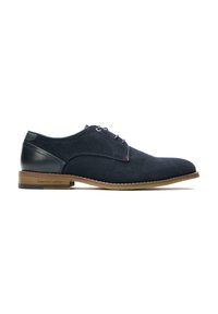 Suede dress shoe in navy blue with a round toe, leather accents, and brown rubber sole. Features laces and subtle stitch detailing.