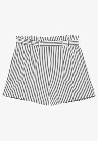 Shorts blancs avec de fines rayures verticales noires, présentant un design plissé et une ceinture en tissu assortie à la taille.