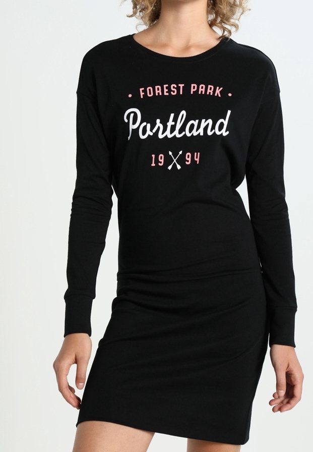 Svart långärmad klänning med grafiken "Forest Park Portland 1994" i vitt och rosa. Mjuk bomullsmaterial, figursydd design, ovanför knäna.
