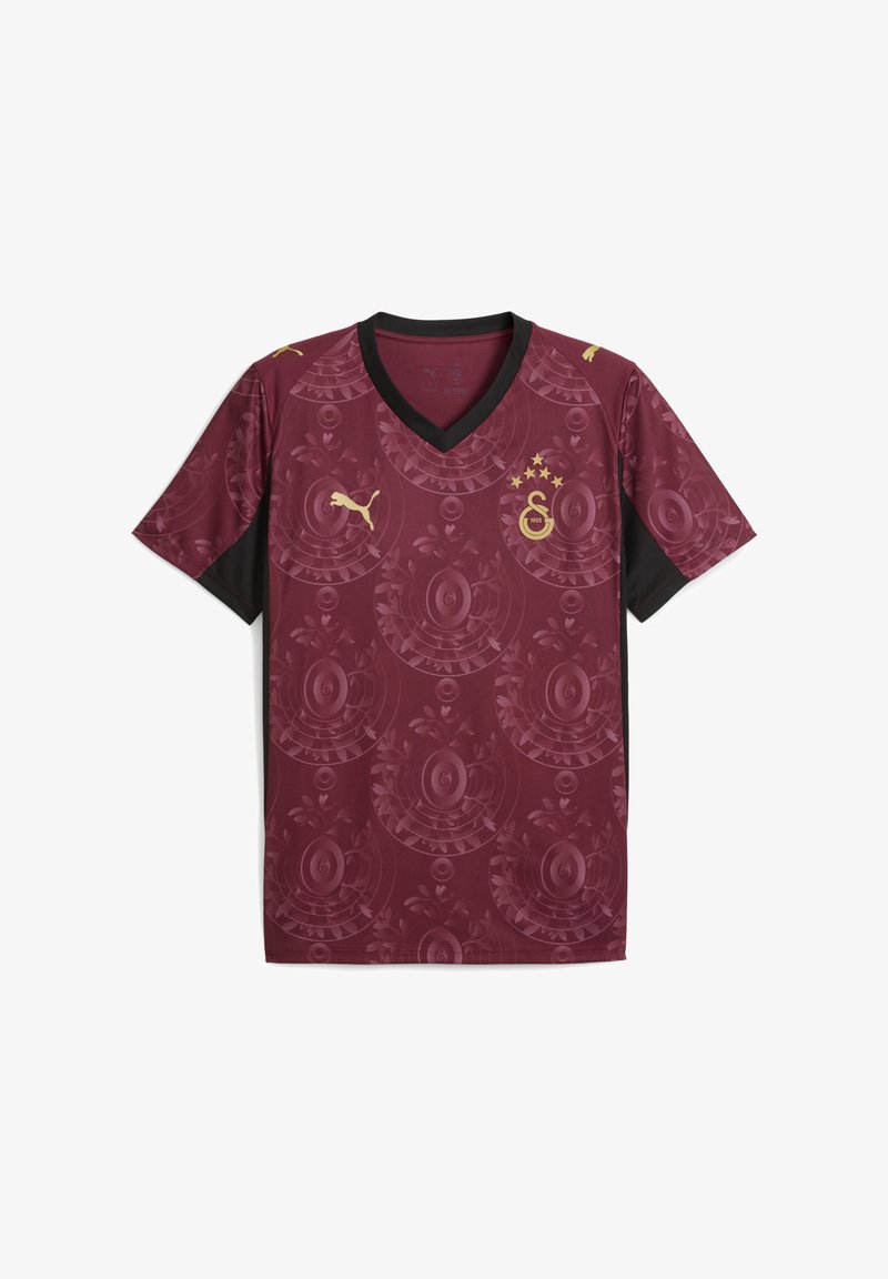 Bordeaux voetbalshirt met een zwarte V-hals, voorzien van een cirkelvormig bloemenpatroon en gouden accenten, waaronder een logo en sterren.