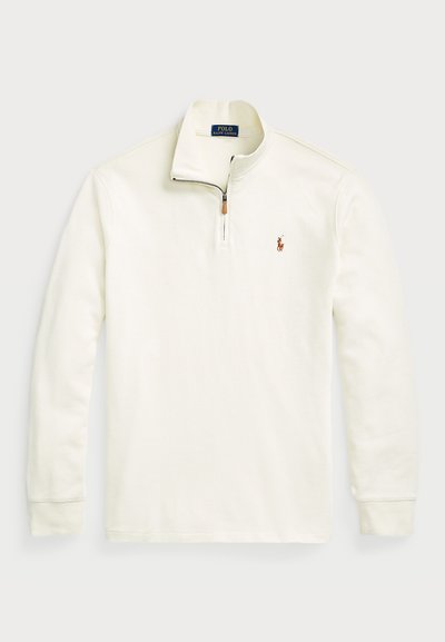 Λευκή μπλούζα φόρμας quarter-zip φτιαγμένη από μαλακό βαμβάκι. Διαθέτει μικρό λογότυπο στο αριστερό στήθος και αντίθεση στη λεπτομέρεια του φερμουάρ.