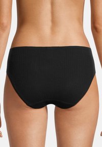 Mutande hipster nere a coste senza cuciture, con una finitura liscia e una leggera elasticità, caratterizzate da una vita bassa e un design posteriore arrotondato.