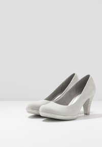 Grå mocka högklackade skor med runda tår, en texturerad konformad klack och en slät innerfoder.