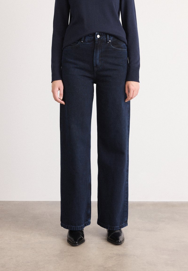 Blauwe wijde jeans van denim, met een hoge taille, zijzakken en een eenvoudige knoopsluiting. Glad textuur en gelijkmatige kleur.