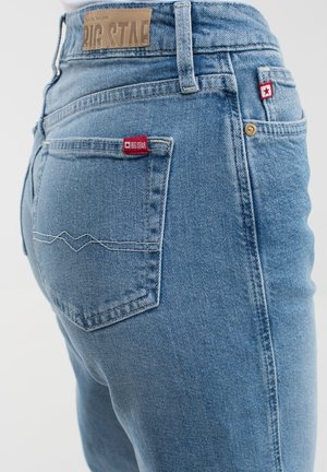 Lichtblauwe denim jeans kenmerken zich door een achterzak met een rode "BIG STAR" label en een zigzagstiksel. Getextureerd, aangesloten ontwerp.