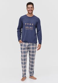Granatowa piżama z długim rękawem z nadrukiem "HOME RELAX SINCE 1989"; piżama w kratkę w kolorze niebieskim, beżowym i białym z elastycznym pasem.