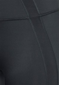 Svarta träningsleggings med en slät textur, plana sömmar och en hög midja för en strömlinjeformad passform. Inga synliga mönster eller detaljer.