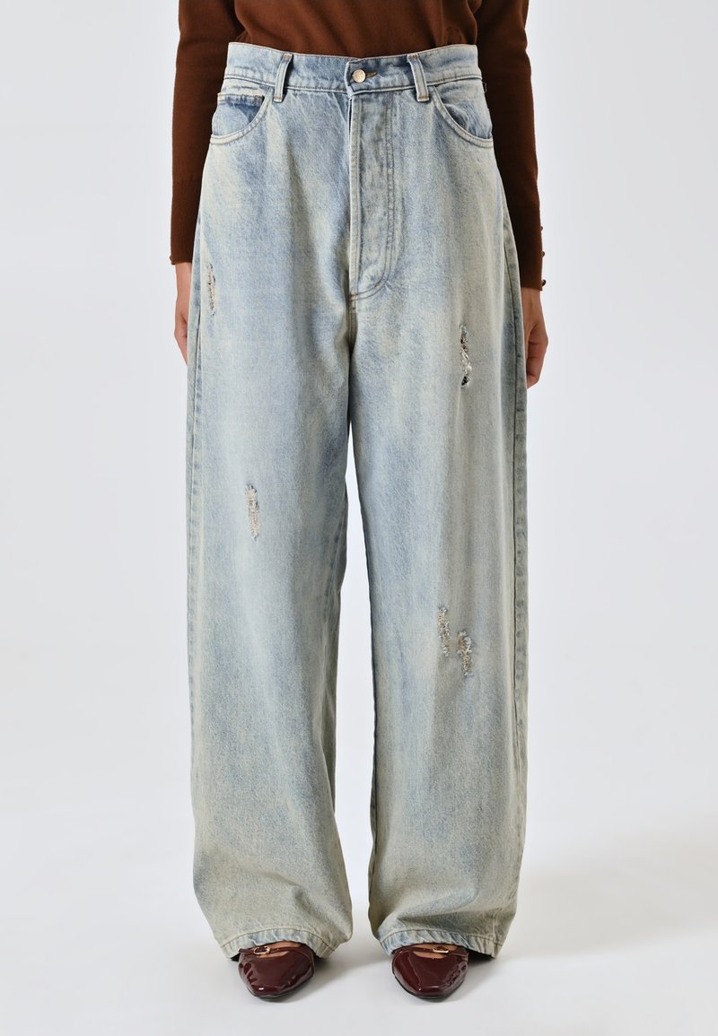 Jeans azzurri chiari a vita alta con gamba ampia e dettagli strappati, dotati di un classico design a cinque tasche e chiusura a bottone tradizionale.