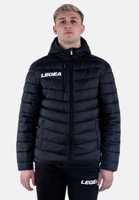 Svart puffjacka med dragkedja fram, huva och vit "LEGEA" logotyp. Har quiltat mönster och mjuk textur, lämplig för kallt väder.