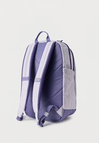 Μωβ και λεβαντίνιο σακίδιο πλάτης Columbia με επενδυμένους ρυθμιζόμενους ιμάντες, πλαϊνή τσέπη και χειρολαβή στο πάνω μέρος, εμφανιζόμενο από πίσω σε λευκό φόντο.