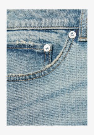 Denim bleu deschis cu marginea buzunarului destrămată, având accesorii din metal argintiu cu inscripția "REISS" gravată și cusătură portocalie contrastantă.