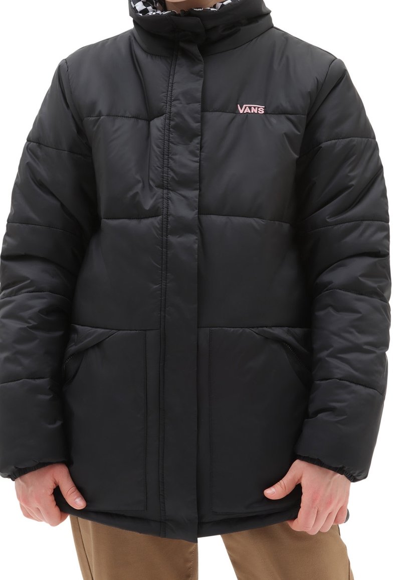 Giacca a vento nera con colletto alto, motivo trapuntato, due tasche frontali e logo "VANS" rosa sul petto. Il materiale sembra elegante e imbottito.