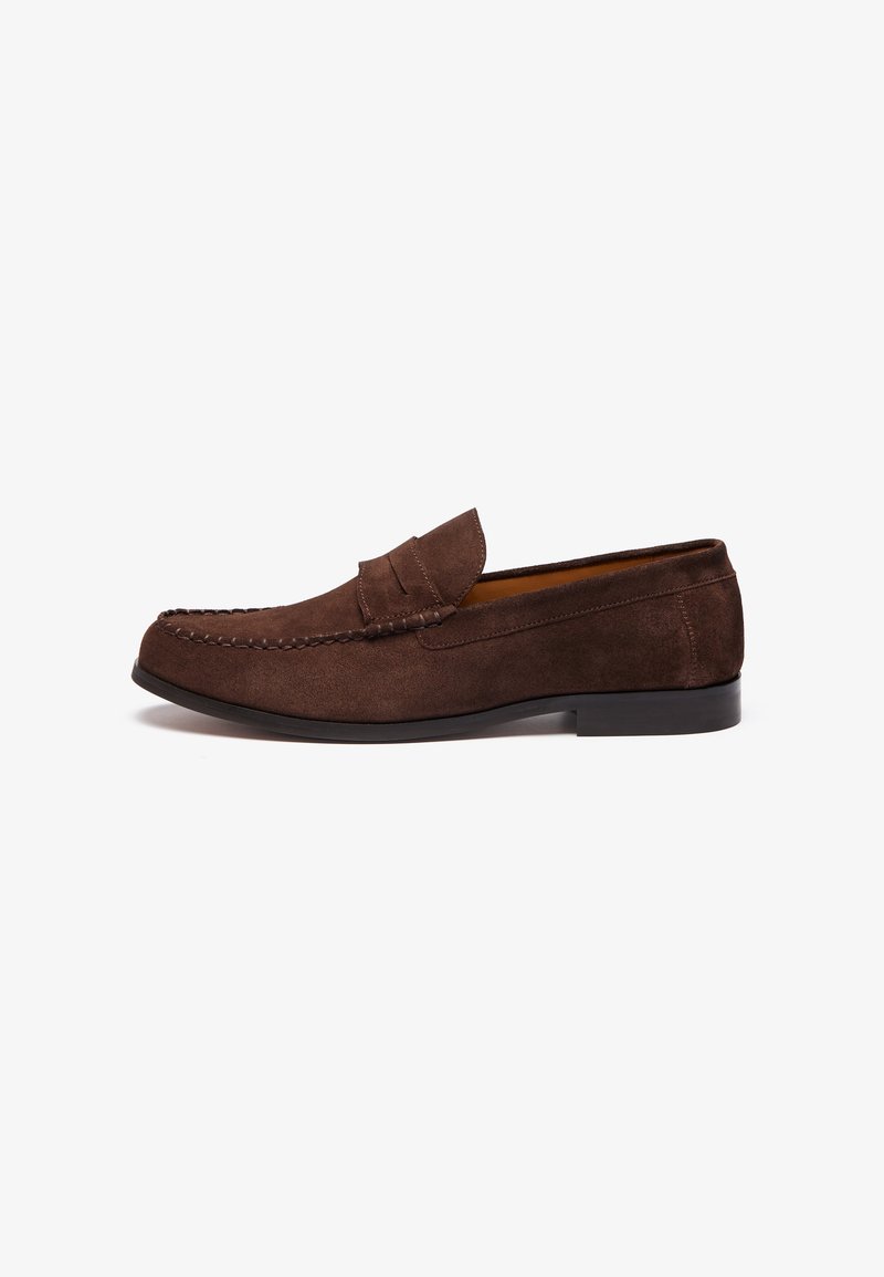 Braune Wildleder-Lederschuhe mit genähten Details, flacher Sohle und erhöhtem Kragen. Glatte Textur und minimalistisches Design.