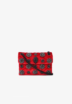 Borsa in velluto trapuntato rosso con patta, decorata con accenti floreali metallici e un pezzo ornamentale centrale, dotata di tracolla a catena nera.