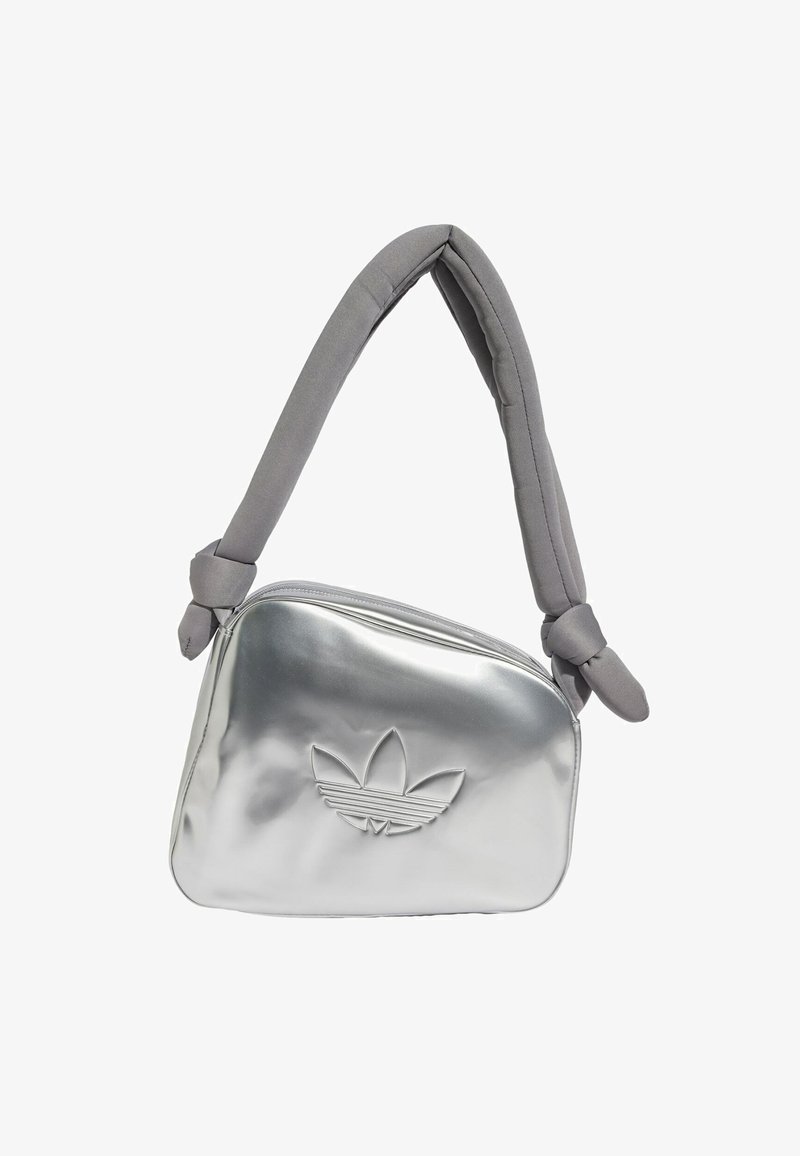 Silver metallic shoulder bag with a padded gray strap, featuring a zip closure and embossed logo design on the front.