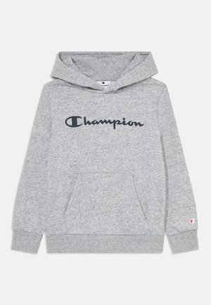 Šedá mikina s kapucňou a predným vreckom. Obsahuje logo "Champion" v tmavomodrej farbe, rebrované manžety a mäkkú, textúrovanú látku.
