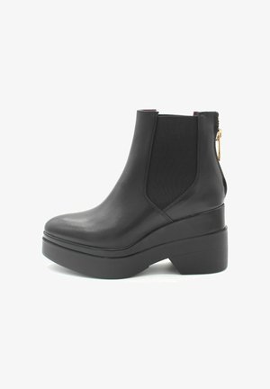 Stivaletti neri in pelle con suola platform spessa, pannelli elastici sui lati e una cerniera sul retro per una facile calzata.